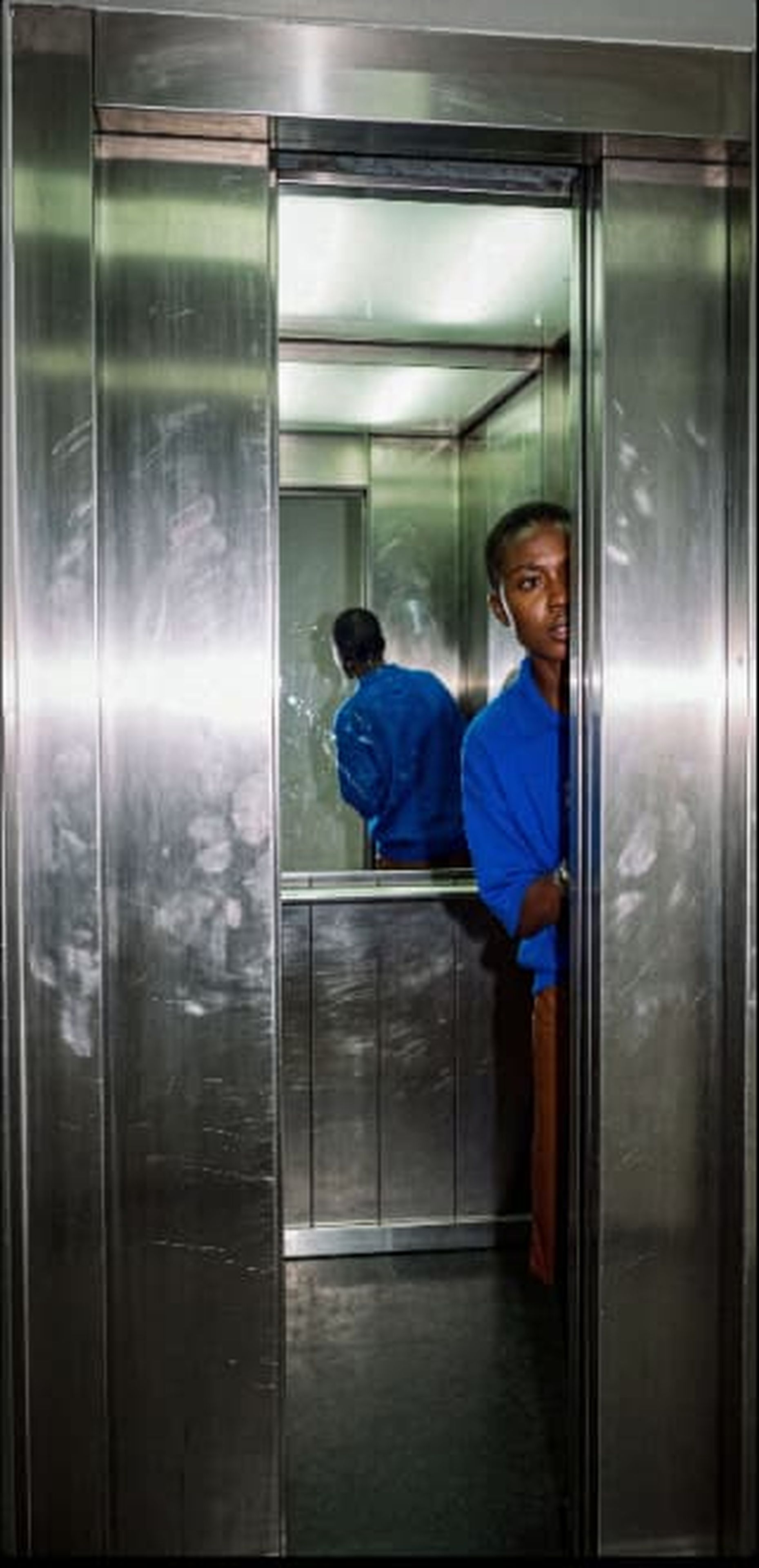 Blue fashion portrait inside a mirrored lift